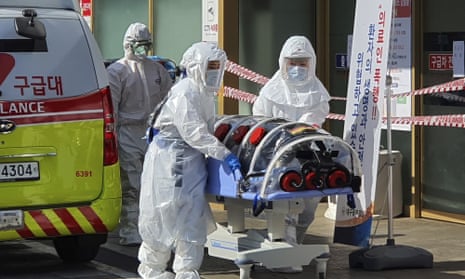 Medical workers wearing protective gear move a patient suspected of contracting the coronavirus in Daegu, South Korea