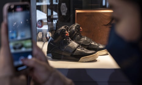 A visitor takes a picture next to Kanye West’s Air Yeezy sneakers at an exhibition in Hong Kong on 16 April. 