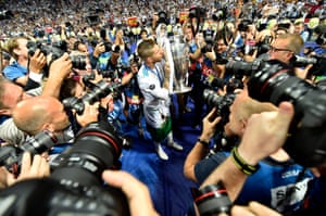 Some of the 160 photographers at the match surround the Real Madrid captain, Ramos, as he kisses the Champions League trophy.