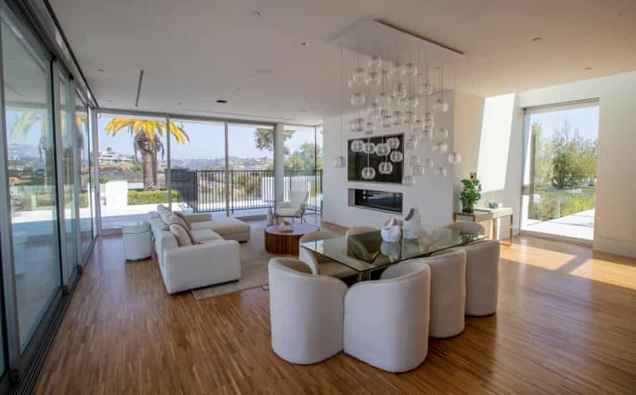 A view of the guest house with sleek wood floors and all white furniture.