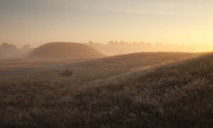 Sunset over the burial mounds, shrouded by mist, at Sutton Hoo. Suffolk, UK.