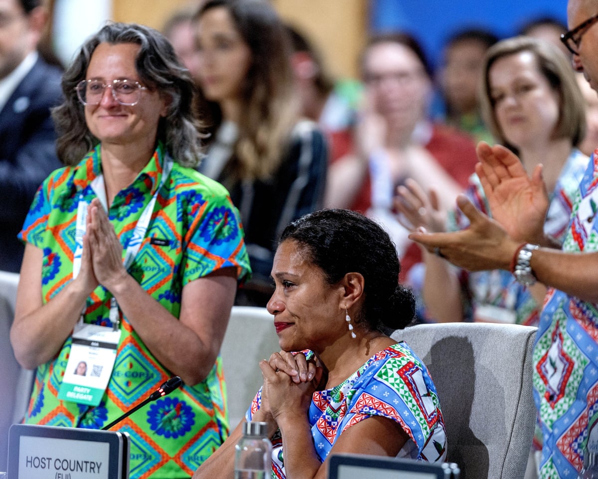 A tearful Lynda Tabuya clasps her hands beneath her chin as delegates applaud