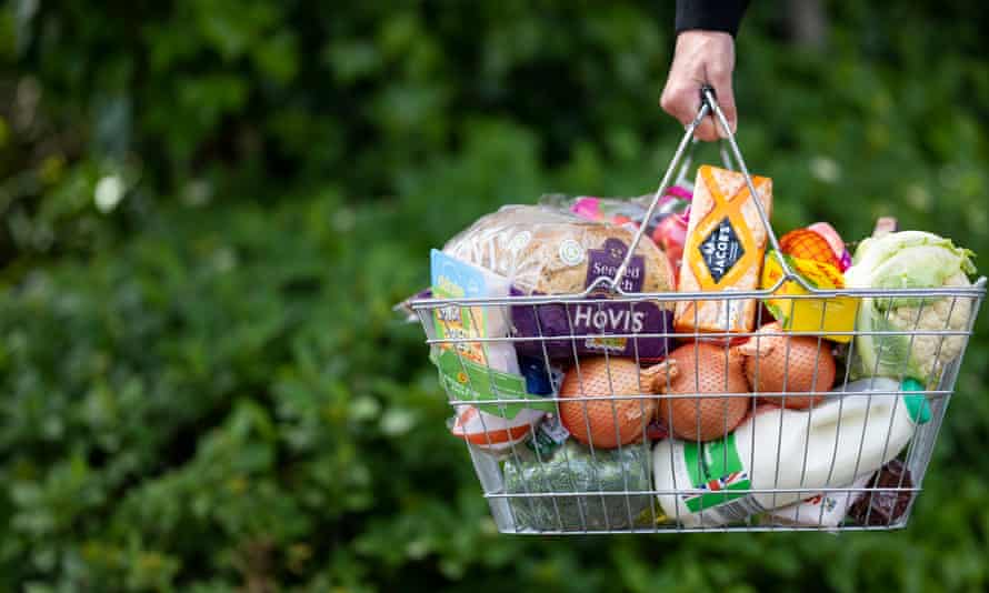 A woman holds a shopping basket of groceries on 22 May.