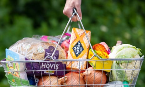 A woman holds a shopping basket of groceries in Cardiff, Wales.