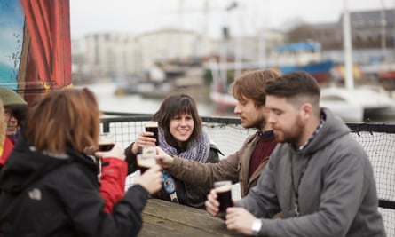 Young people clink glasses of Guinness on the Grain Barge, Bristol