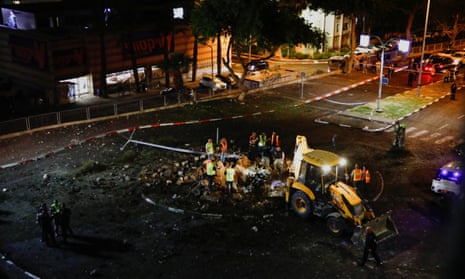 Israeli rescue force members inspect the site where a projectile fell in Haifa.