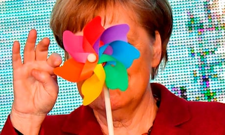 Angela Merkel spins a toy windmill, obscuring her face