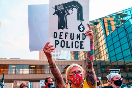 A protester holds a sign reading “Defund the police” during a demonstration in Minneapolis, Minnesota.
