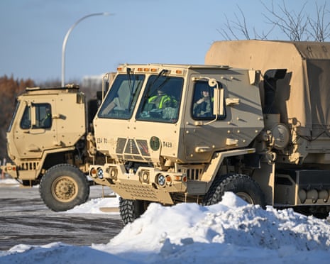 Minnesota National Guard trucks parked near the Minneapolis federal building, which houses ICE offices and a detention centre