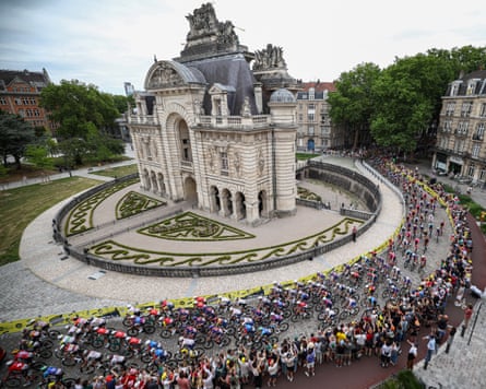 The peloton passes the Porte de Paris arch near the start of the first stage of the Tour de France.