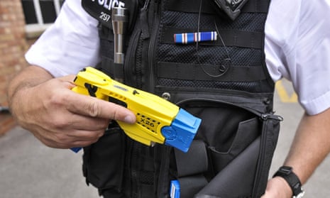 A male police officer with a drawn stun gun