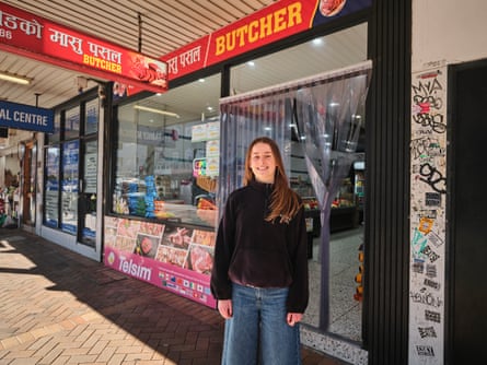A young woman in front of a butcher shop