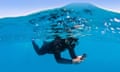 Person snorkelling and using an underwater camera