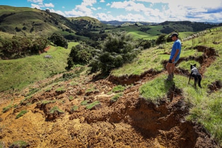 한 농부가 허리케인 가브리엘 동안 산사태로 변형된 자신의 땅을 바라보고 있습니다.