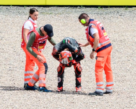 Marco Bezzecchi is checked over by race stewards after crashing out.