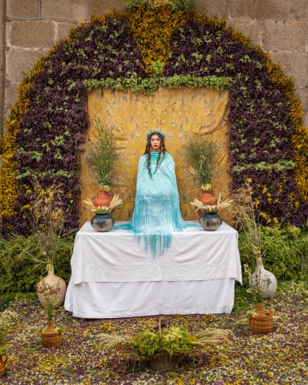 A ‘Maya’ girl sits on an altar during the traditional celebration of ‘Las Mayas’ on the streets of the small village of Colmenar Viejo