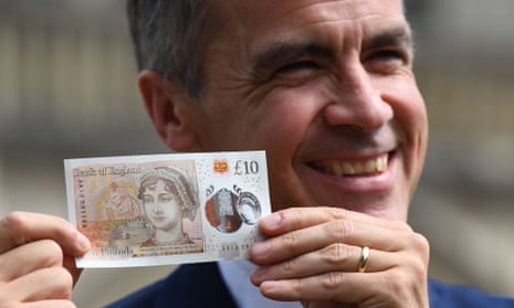 Bank of England Governor Mark Carney poses with one of the central bank’s new ten pound notes, featuring author Jane Austen
