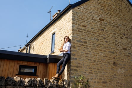 Hannah Bourne-Taylor stands on a garden wall under a swift brick built into a stone house