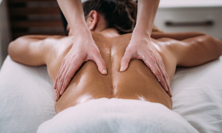 Sports back massage A physiotherapist massages a patient with an injured lower back muscle. Treatment of sports injuries.
