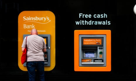 A man withdraws cash from a Sainsbury’s Bank ATM