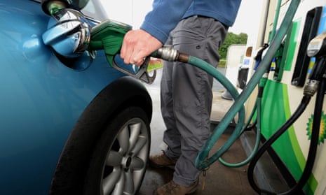 A man refuels a car at a petrol station