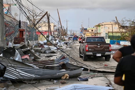 A car drives through the a destroyed neighborood following the passage of Hurricane Melissa, in Black River, Jamaica on October 29, 2025.