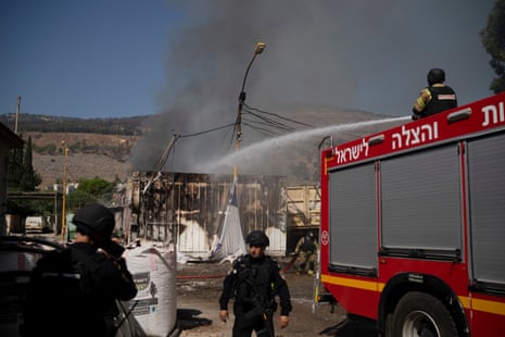 Israeli firefighters work to extinguish a fire after a rocket, fired from Lebanon, hit a local municipality storage in Kiryat Shmona, northern Israel.