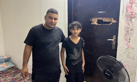 Malak Shihab and her father in their damaged home.