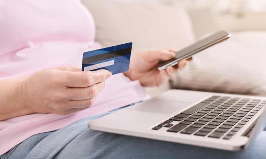 Woman with phone, bank card and laptop