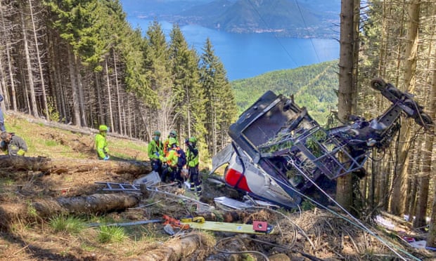 Rescuers work by the wreckage of a cable car after the crash near the summit of the  Monte  Mottarone line in northern Italy, on 23 May.