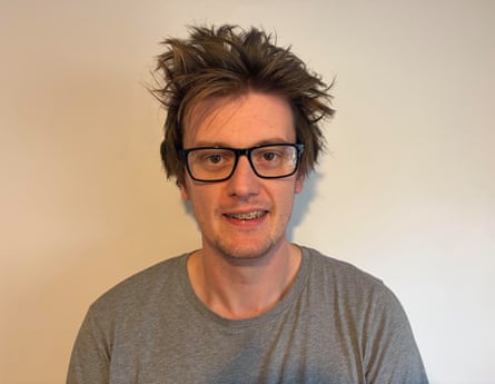 Lawrence Barratt, a man with tousled hair and glasses, smiles at the camera