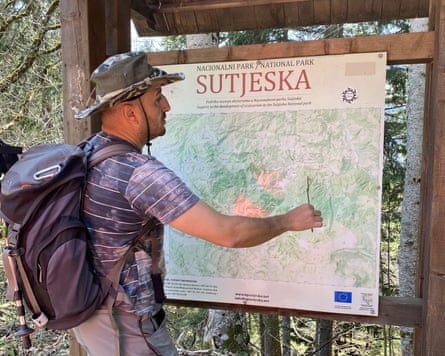 Man with backpack looks at a map