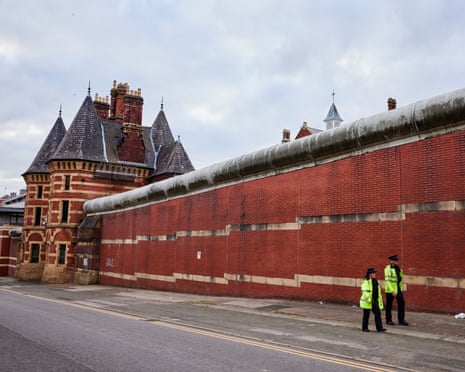 Police officers outside a high-walled prison