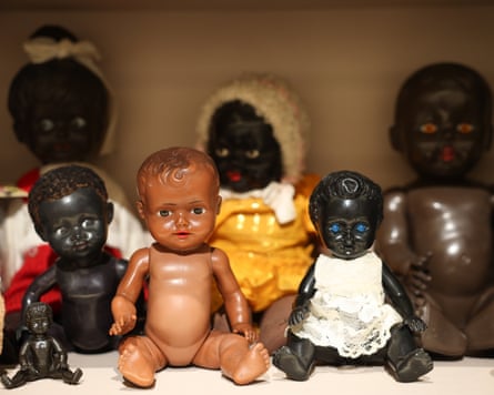 Two lines of seated dolls, all black except for one