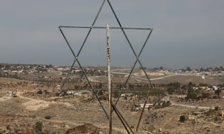 A metallic Star of David attached to a rusty post