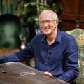 Portrait of Bernard in a blue shirt while sat at a table