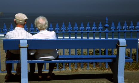 Retired couple on bench overlooking the sea