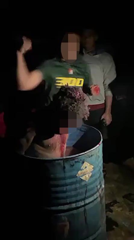 A still from the video showing a West Papuan man, bound in a water-filled barrel and being beaten and cut with knives, allegedly by Indonesian soldiers.