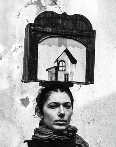 A person balancing a small prop stage on their head