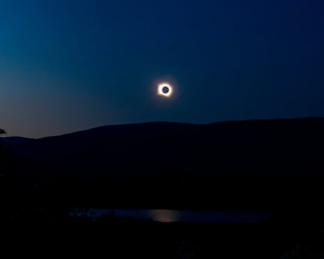 Thousands of people gather to observe a total solar eclipse over the Madrid town of Buitrago del Lozoya, Spain.