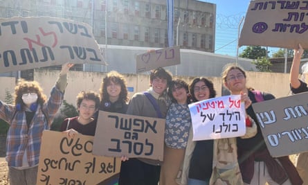 people hold up signs in hebrew