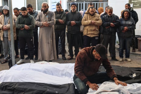 Palestinians mourn near the bodies of relatives at Rafah's Al-Najjar hospital on 21 February 2024 following overnight Israeli airstrikes on the southern Gaza Strip.