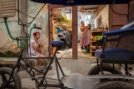 A bicycle taxi parked outside a barber shop in Cuba