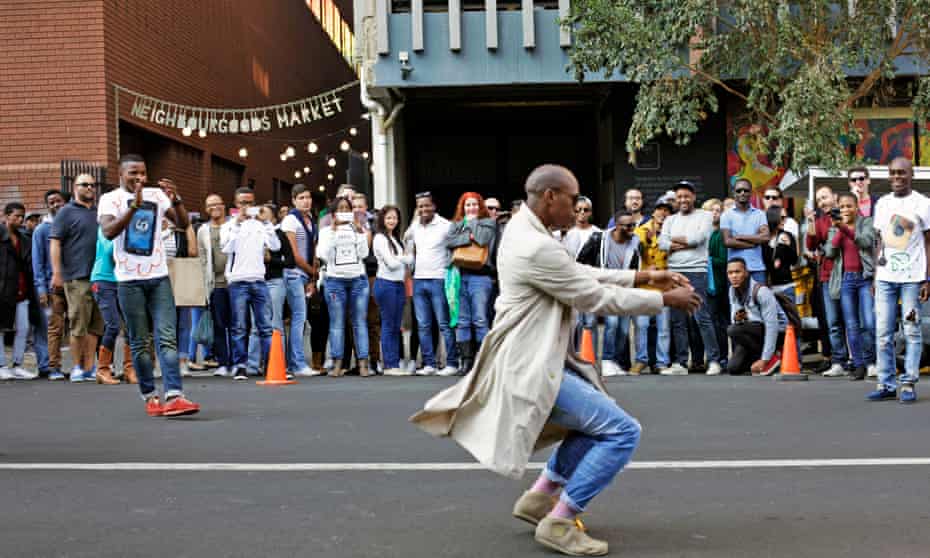 A man performs a street dance in front of crowds in Braamfontein, Johannesburg, South Africa