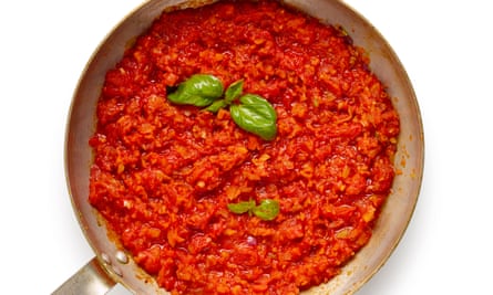 A mixed sauce of tomatoes and basil mashed together in a pan.