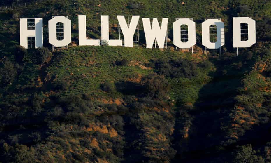 The iconic Hollywood sign is shown on a hillside above a neighborhood in Los Angeles.