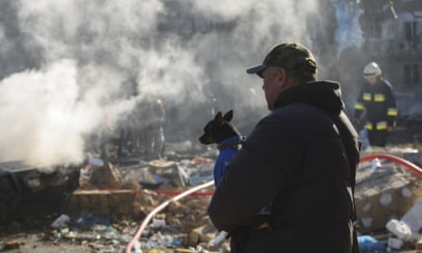Firefighters and people stand beside destroyed bulding following shelling of a residential area in Kyiv, Ukraine on Friday, March 18, 2022 as Russian troops try to encircle the Ukrainian capital as part of their slow-moving offensive. Russian Shelling in A residential Area in Kyiv, Ukraine - 18 Mar 2022