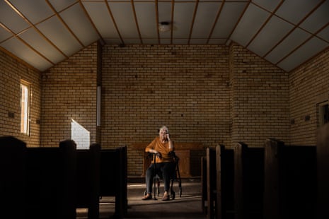 Frances Wernblom seated in the centre of the church, with a brick wall behind her and pews visible to each side