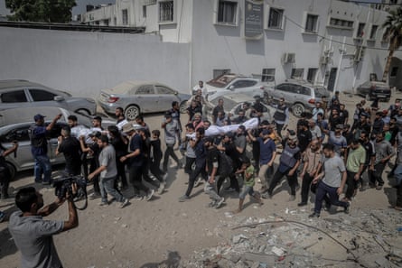 People carry wrapped bodies through the streets of Gaza.