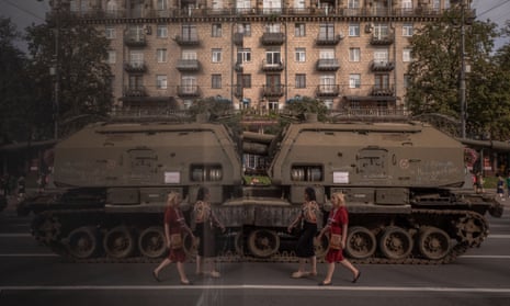 Two women walk past destroyed Russian armored military vehicles displayed on the main Khreshchatyk street.